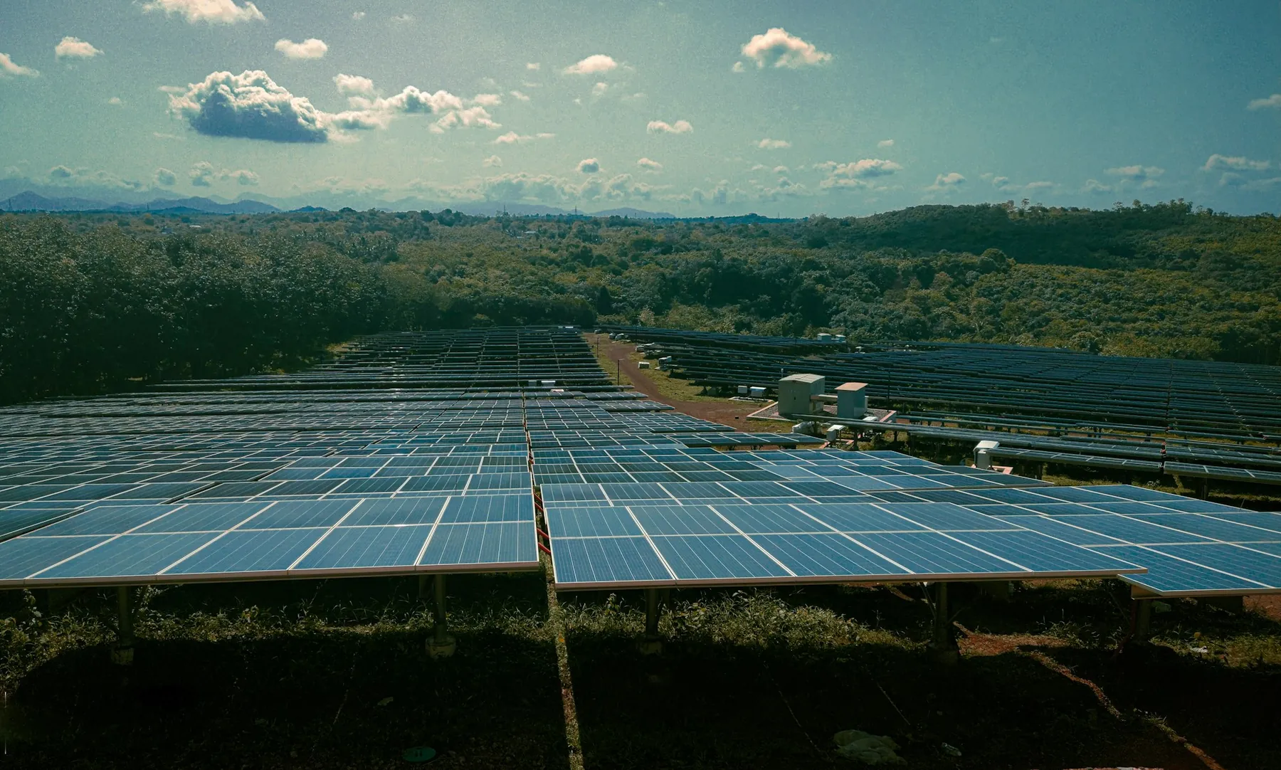Rows of solar panels across green countryside