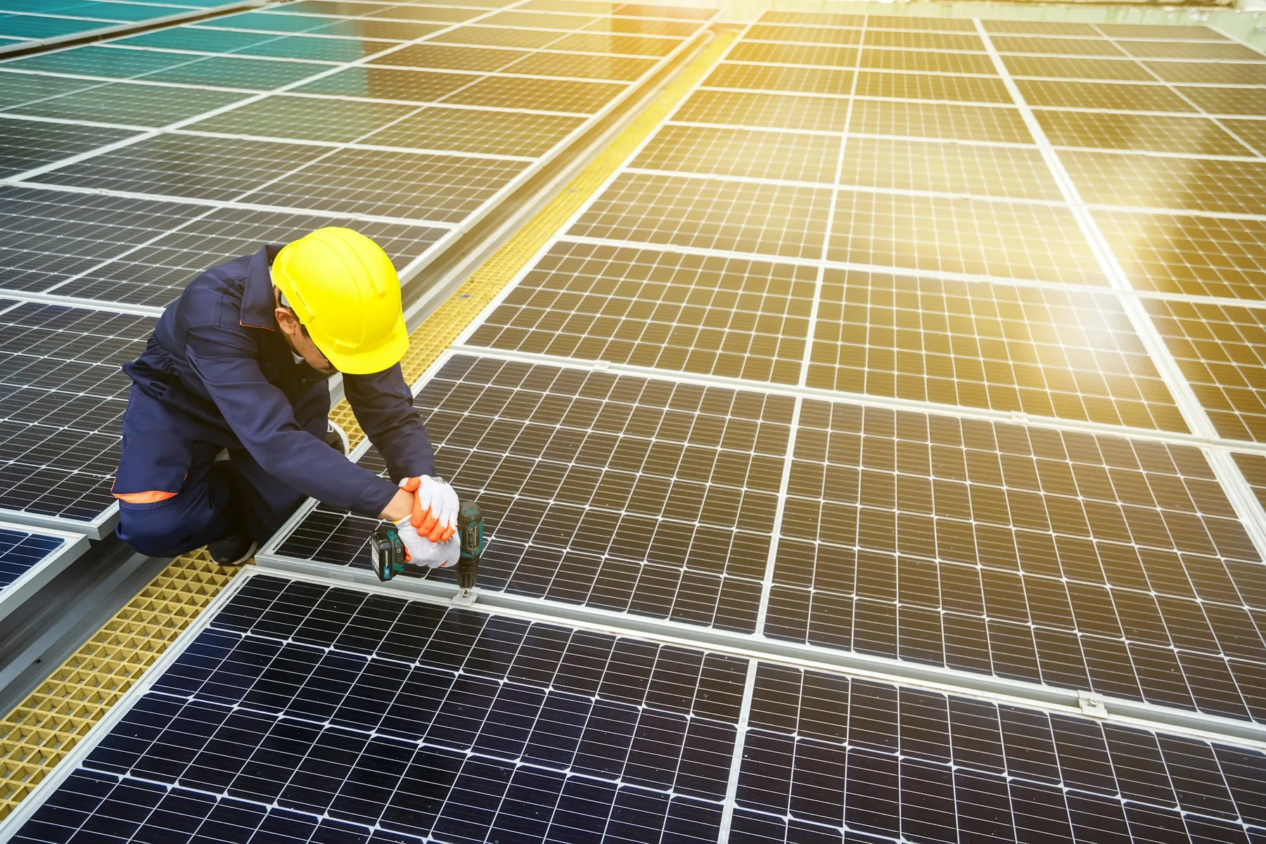 Installer fixing solar panels in bright sunlight